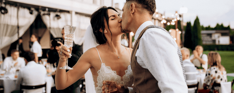 Couple kiss and raise their glass to celebrate their wedding